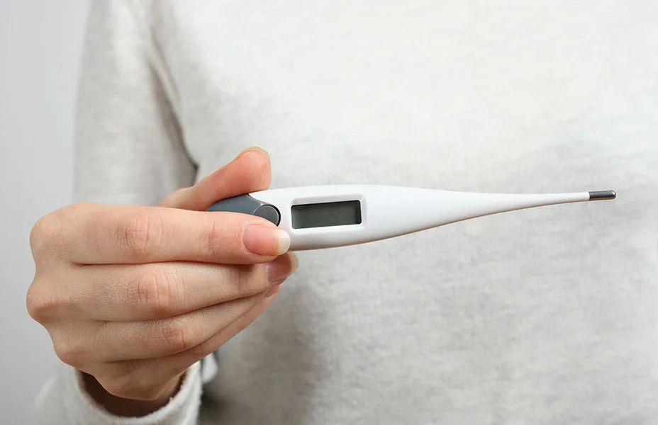 Person der holdet et termometer